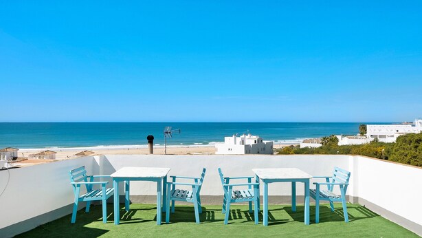 A terrace with a view of the sea, white walls, and blue chairs. - Apartment 'Celeste' with Sea View, Shared Terrace and Wi-Fi (conil de la frontera)