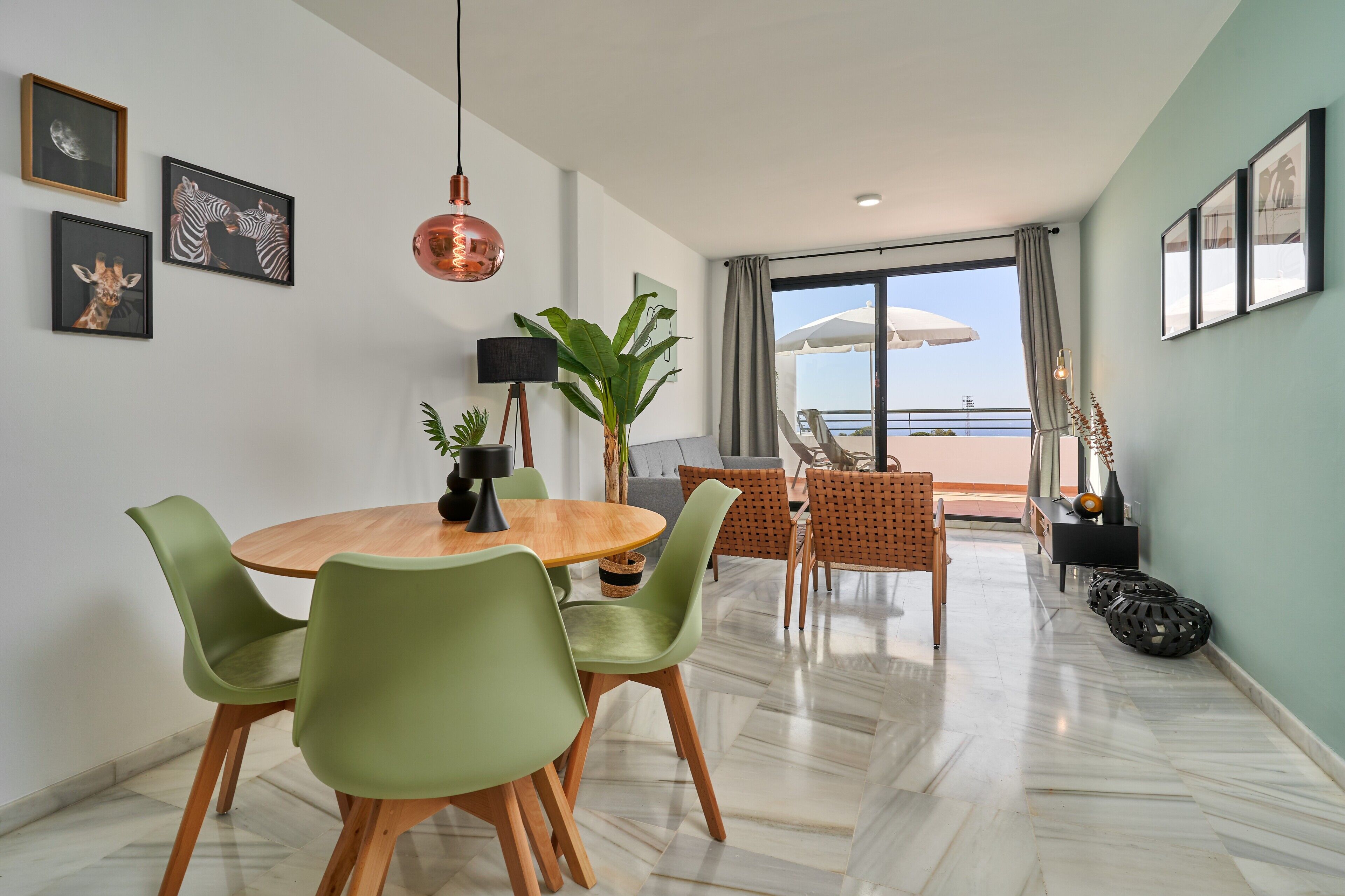 Een moderne woonkamer met een eethoek, een groot raam met uitzicht en een balkon.