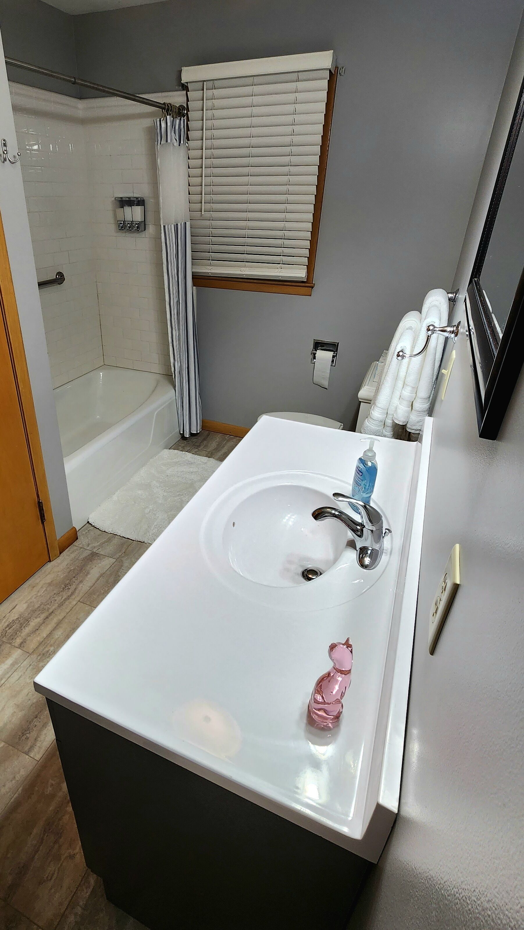 Une salle de bain avec un lavabo blanc, une douche et une baignoire.