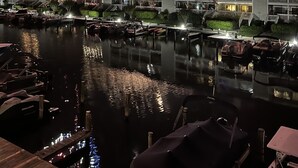 A waterfront hotel with multiple balconies overlooking a marina.