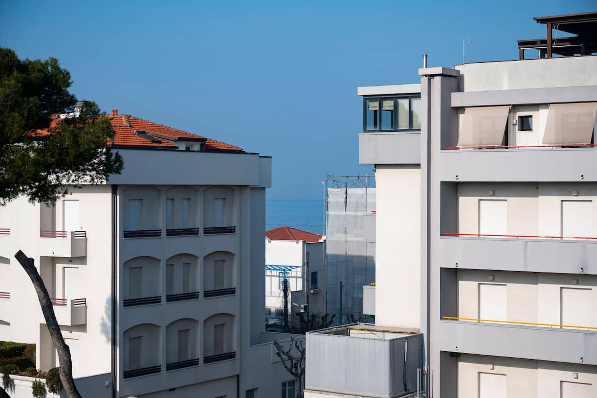A modern building with multiple balconies and a clear view of the sea.