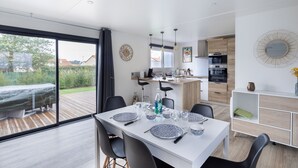 A modern kitchen with a dining area. - New Chalet for 8 in a residence with pool (Bretignolles-sur-Mer)