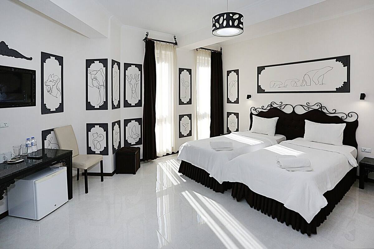 A modern hotel room with a large bed, a desk, and a chair.