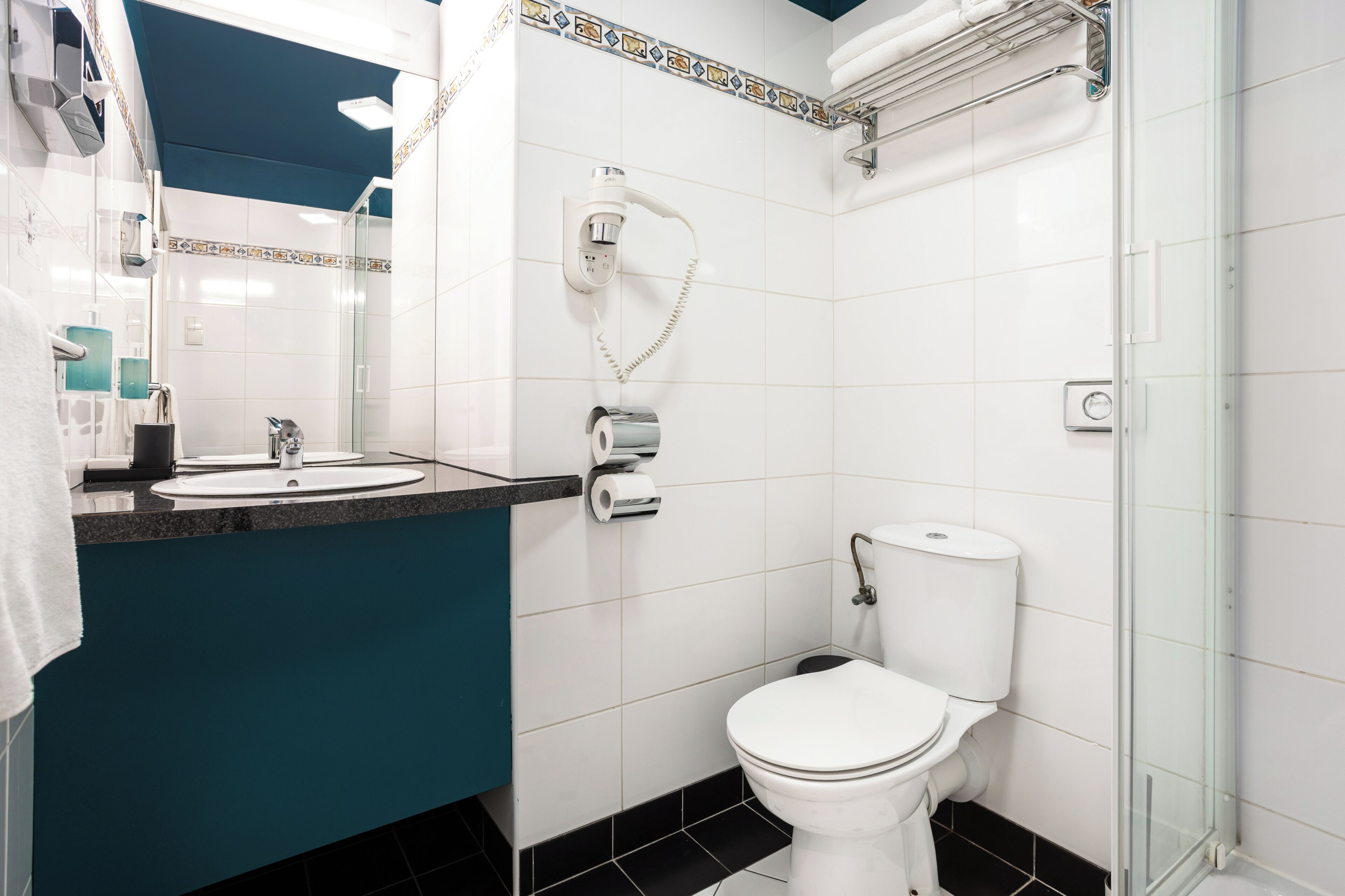 A bathroom with a toilet, sink, and shower.