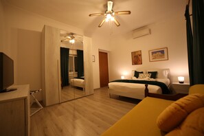 Relax in a spacious room with a large bed, flat-screen TV, and comfortable seating area.
