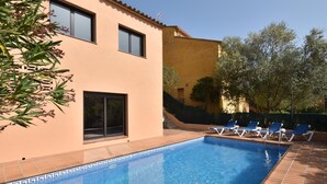 A swimming pool with blue tiles, a tiled deck, and blue lounge chairs. - Casa La Torreta (Begur) (Begur)