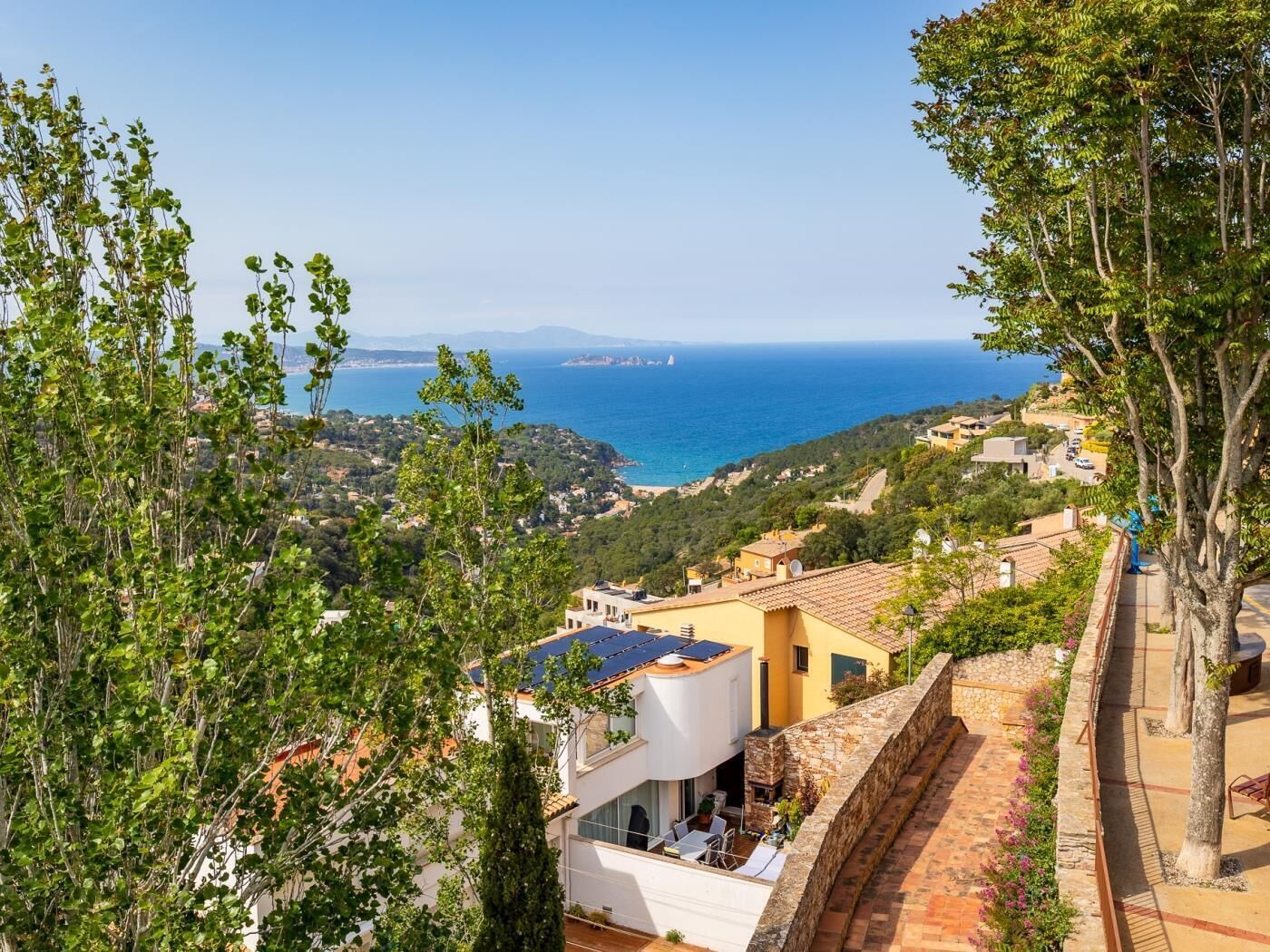 Une villa située sur la côte, dotée d’une terrasse, de murs en pierre et offrant une vue sur la mer.