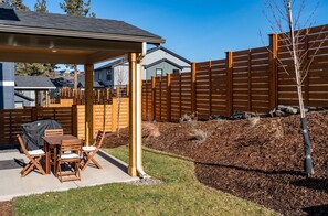Relax in a serene outdoor space with a covered patio featuring a table and chairs.