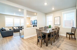 Relax in a cozy living area with a dining table and comfortable seating, perfect for unwinding with a flat-screen TV and a view of the outside.
