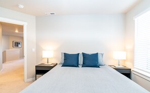 Relax in a spacious bedroom with a large bed, two bedside tables, and a framed picture on the wall.