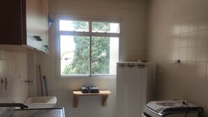 Eine Küche mit Fenster, Spüle, Herd und Arbeitsplatte.