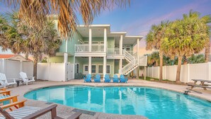 A pool area with lounge chairs, a wooden deck, and a two-story building with balconies. - The Tipsy Turtle features a playroom for little ones, an arcade game room for bi (Port Aransas)