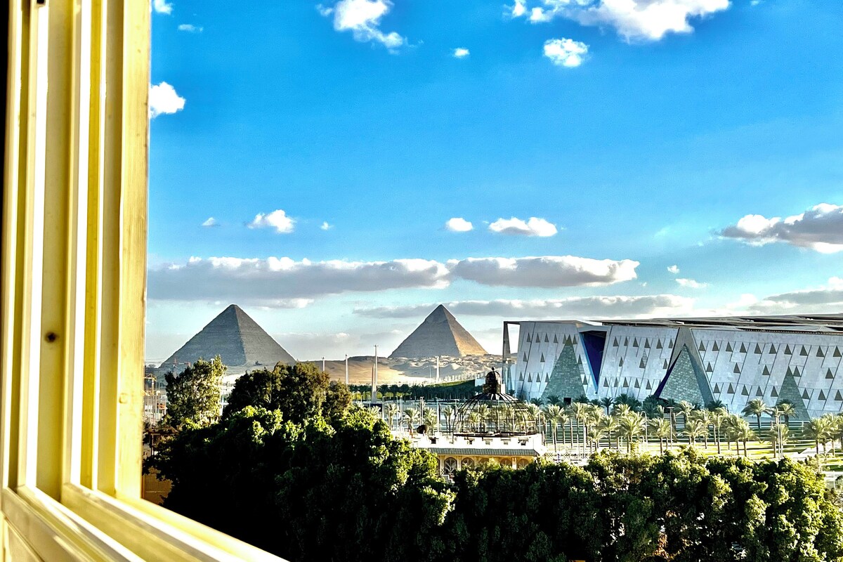 Vista de pirámides y un edificio moderno con diseño geométrico.