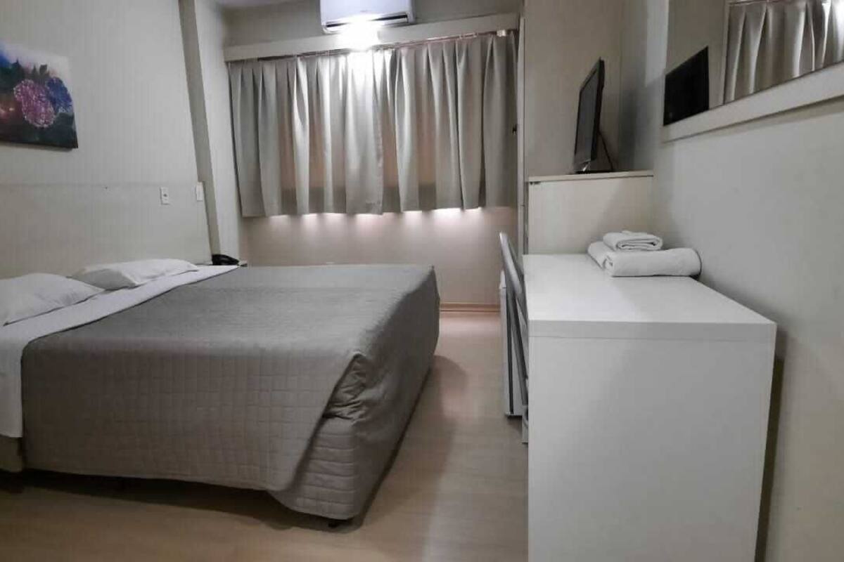 Une chambre d’hôtel avec un lit, un bureau et une télévision.