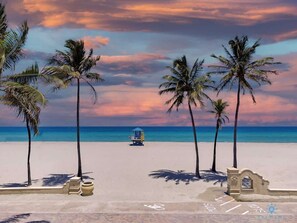 Una playa con palmeras, una torre de salvavidas y cielo despejado.