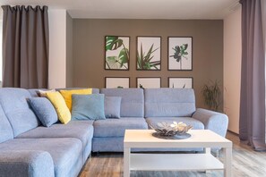 A modern living room with a grey sectional sofa, a white coffee table, and framed botanical prints on the wall. - Villa with Private Pool in Vela Luka (Vela Luka)