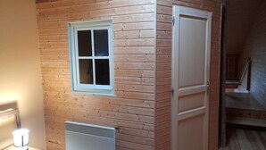 A small, wooden-paneled room with a window, a radiator, and a door. - Maison Entière Avec Cour Intérieure (Monthureux-sur-Saône)