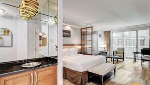 A modern hotel room with a large bed, a desk, and a view of the city. - Las Vegas Suite | Jacuzzi, Balcony & Strip Views (Las Vegas)