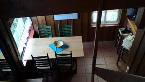 A wooden dining area with a table and chairs, a window, and a view of the outside. - Monty's vacation home (Simmerath)
