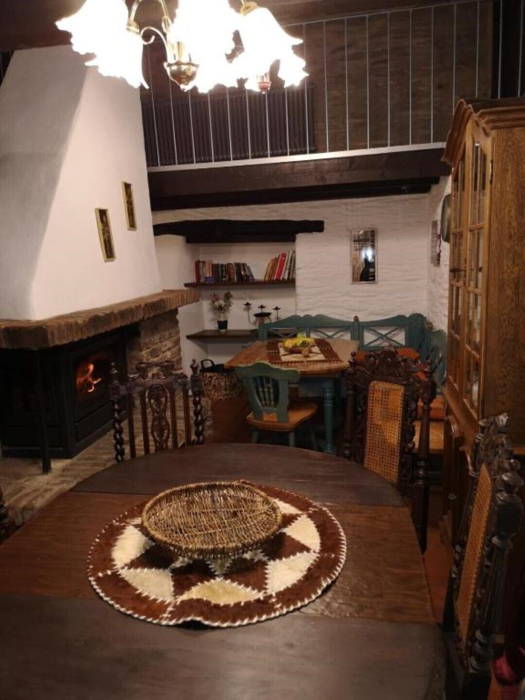 Ein gemütlicher Essbereich mit Holztisch, Stühlen und einer gewebten Tischdecke.