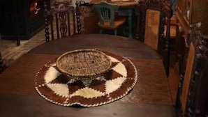 Un coin repas chaleureux avec une table en bois, des chaises et un set de table en fibres tressées.