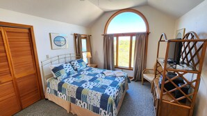 A bedroom with a bed, a wooden wardrobe, a desk with a chair, and a window with curtains. - Beachfront - Community Pool/Pickleball Access! (St. George Island)
