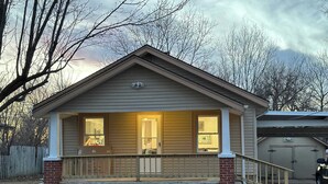 Ein eingeschossiges Haus mit Veranda, Garage und umzäunter Garten.