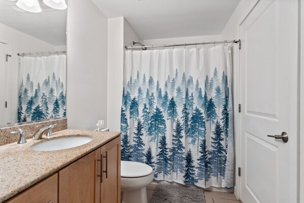 A bathroom with a sink, mirror, and toilet.