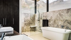 A modern bathroom with a bathtub, a shower, and a sink.