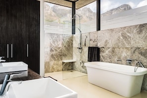 A modern bathroom with a bathtub, a shower, and a sink.