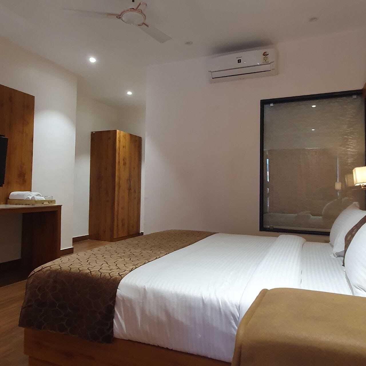 Una camera d'albergo con un letto, una scrivania, un armadio e una finestra.