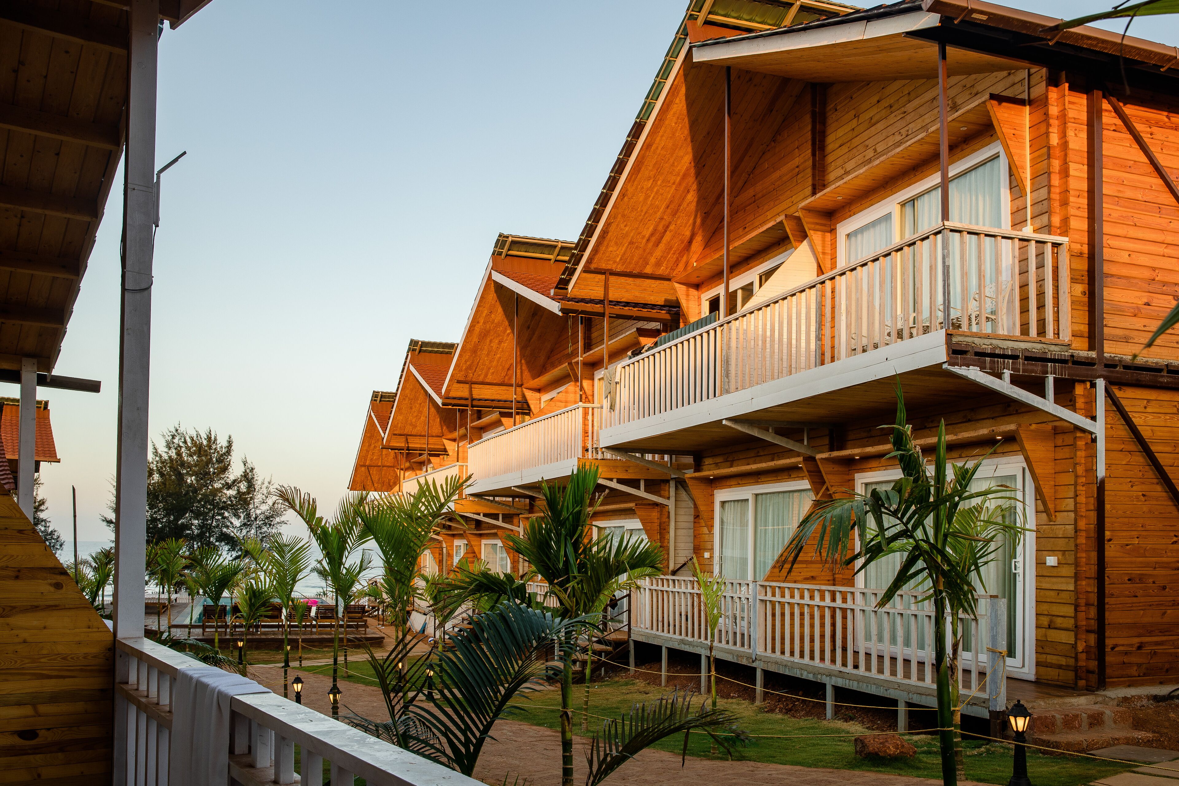 Un hotel tipo cabaña de madera con varios balcones y vista al océano.
