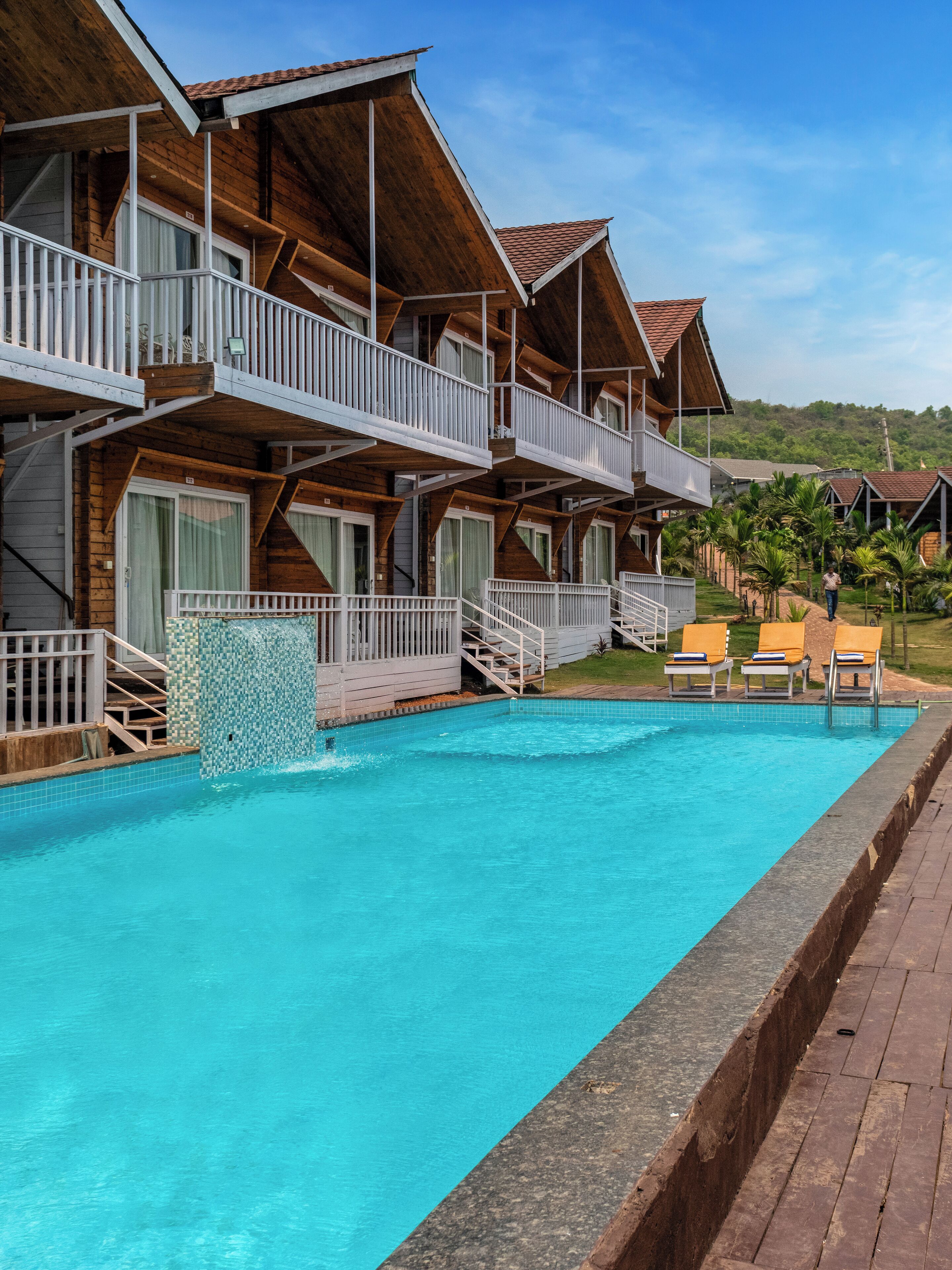 Un bâtiment en bois doté de balcons et d’une piscine.