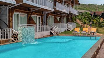 Un bâtiment en bois doté de balcons et d’une piscine.