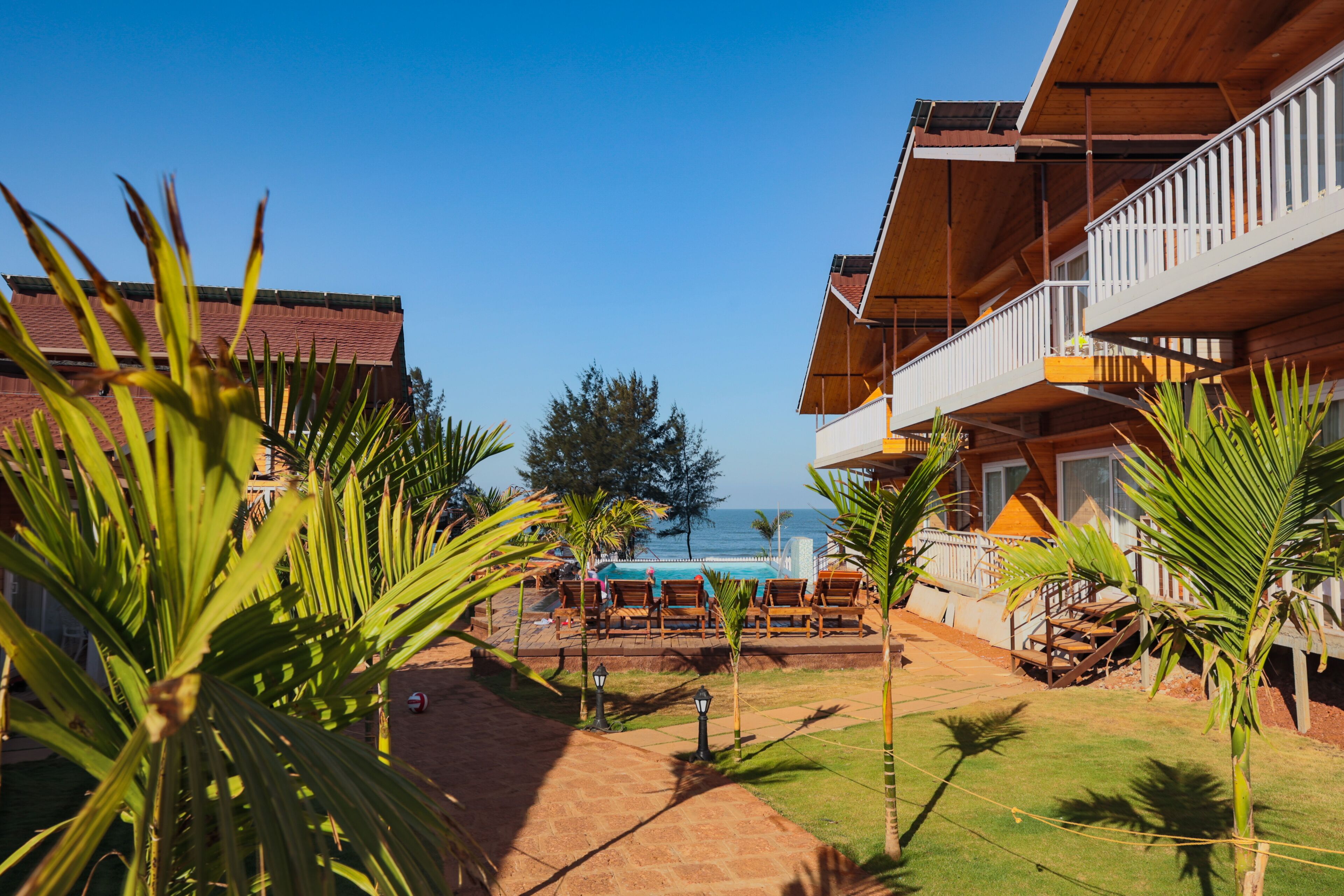 A resort with a pool, outdoor seating, and a view of the ocean.