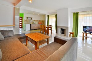 Una sala de estar moderna con un sofá, una mesa de madera y un televisor.