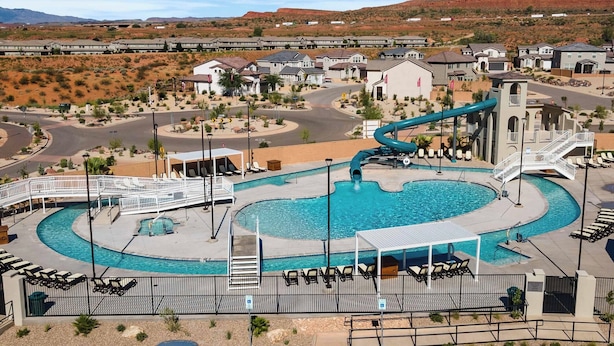 A resort with a swimming pool, a water slide, and a view of desert hills. - TNT Sun Adventures: Hot Tub, Arcade, Air Hockey (Washington)