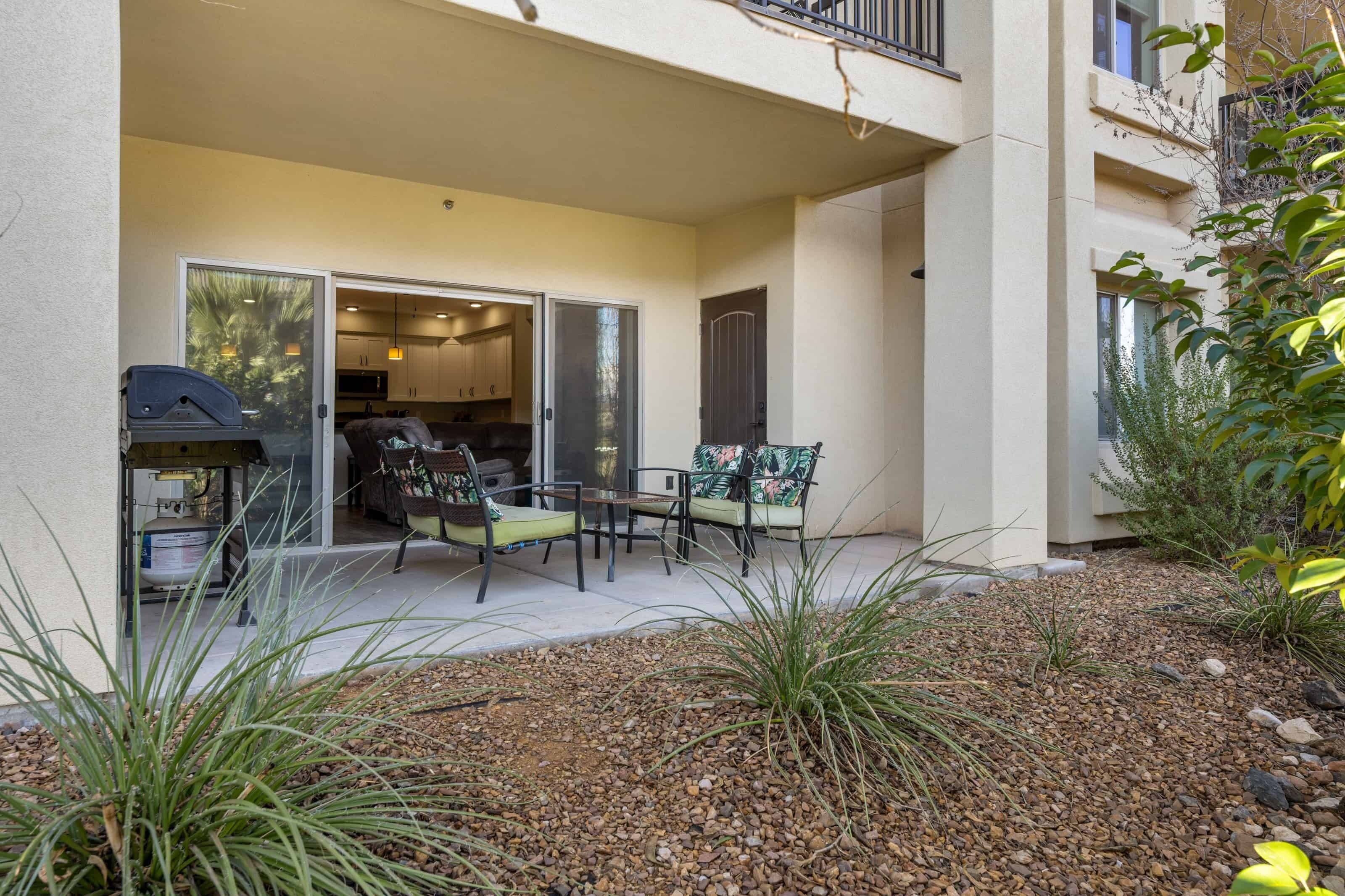 A patio area with outdoor seating, a grill, and a view of the building's interior.