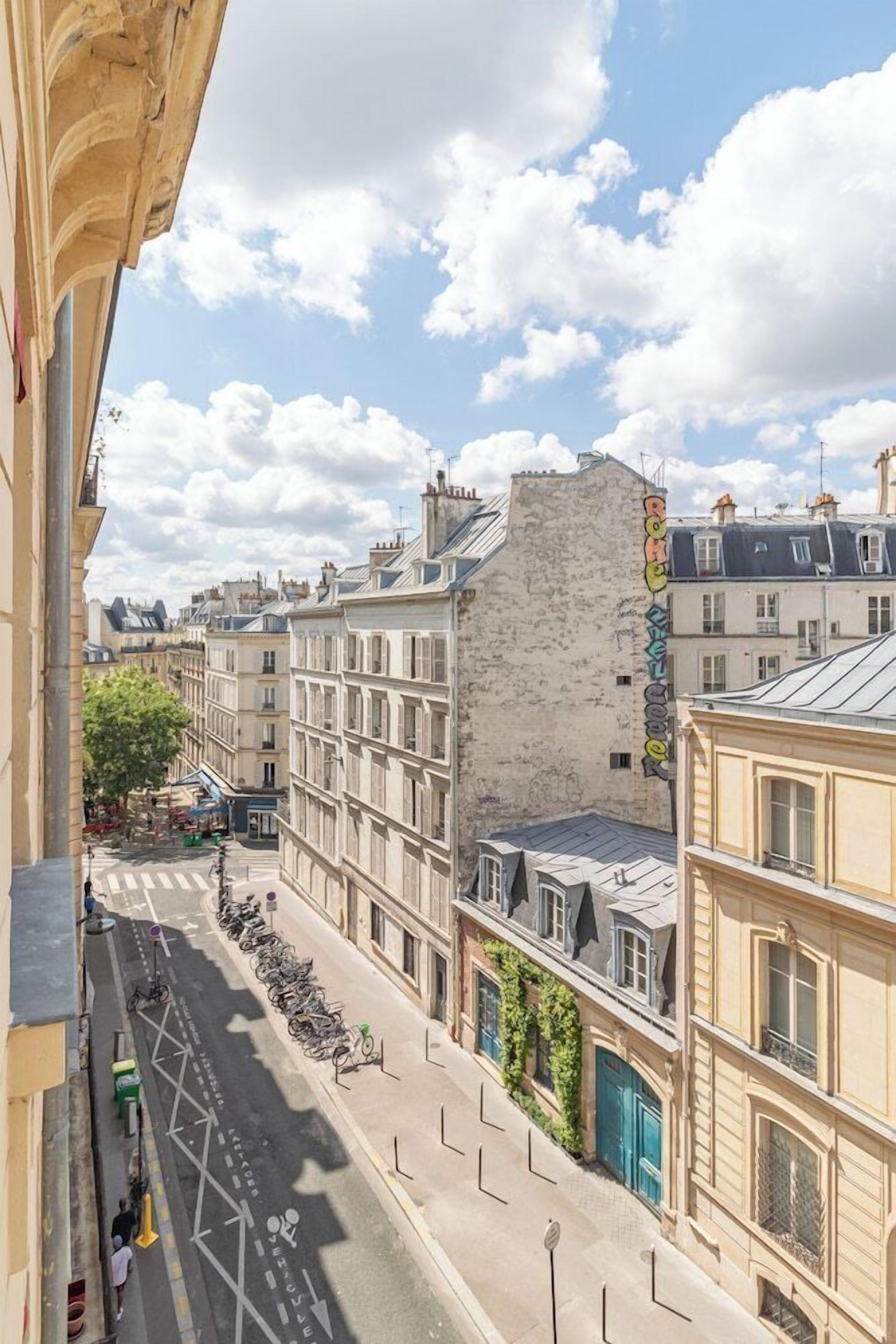 Une vue de rue avec des bâtiments, un ciel dégagé et une piste cyclable.