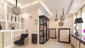 A modern hotel lobby with a seating area, a glass display cabinet, and a reception desk. - Hotel Riviera (Paris)