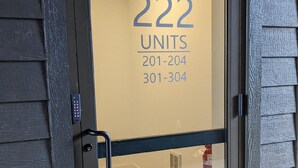 A hotel entrance with a glass door displaying '222 UNITS 201-204 301-304'. - Luxury 1 Bedroom Downtown Traverse City (Traverse City)
