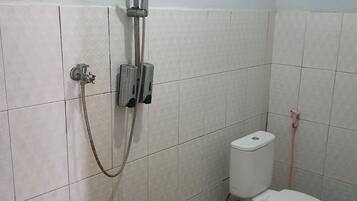 Un baño con ducha, inodoro y paredes de azulejos.