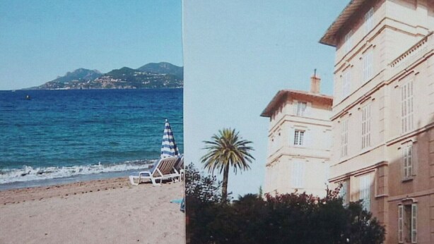A beach with a clear view of the sea and a distant mountain. There is a beach chair and a striped umbrella. - Villa Saint Henri (Cannes)