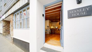 Une maison avec une enseigne indiquant « STANLEY HOUSE » et dont on peut voir l’intérieur, notamment une cuisine.