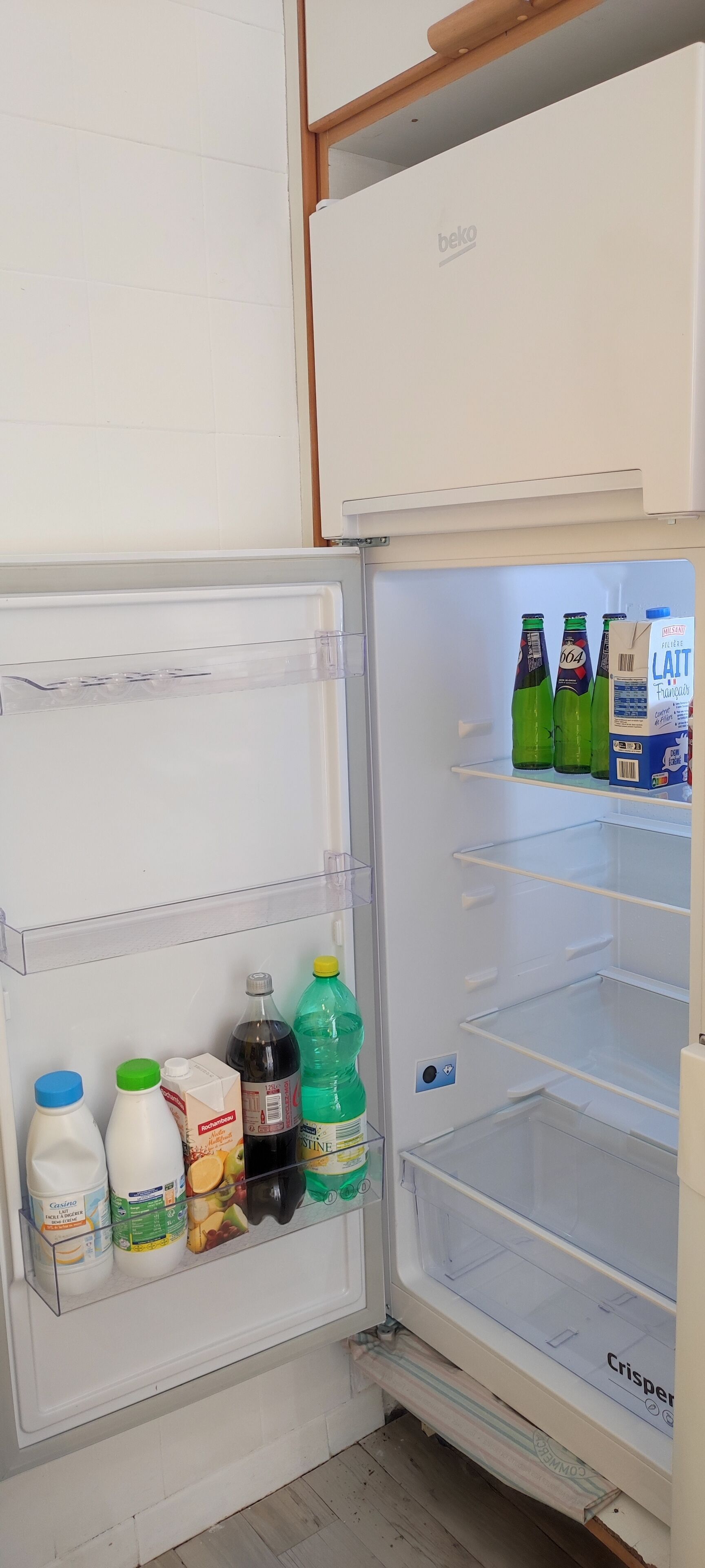 Un refrigerador con leche, jugo y botellas de agua en su interior.