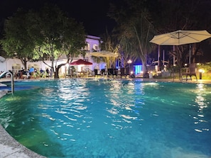 Una piscina al aire libre, sombrillas, guardavidas en la propiedad