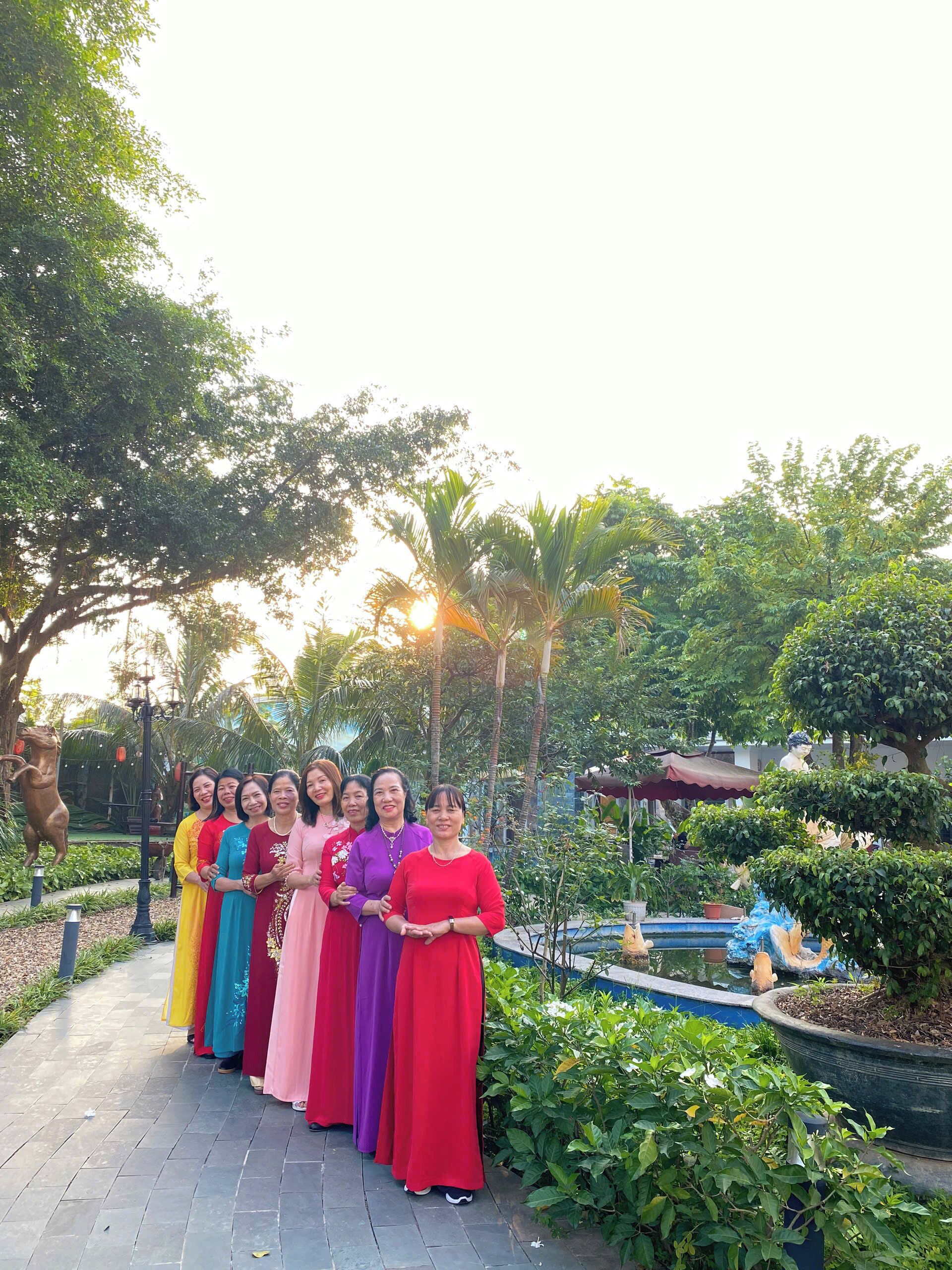 Un grupo de personas en un jardín con una fuente y estatuas.