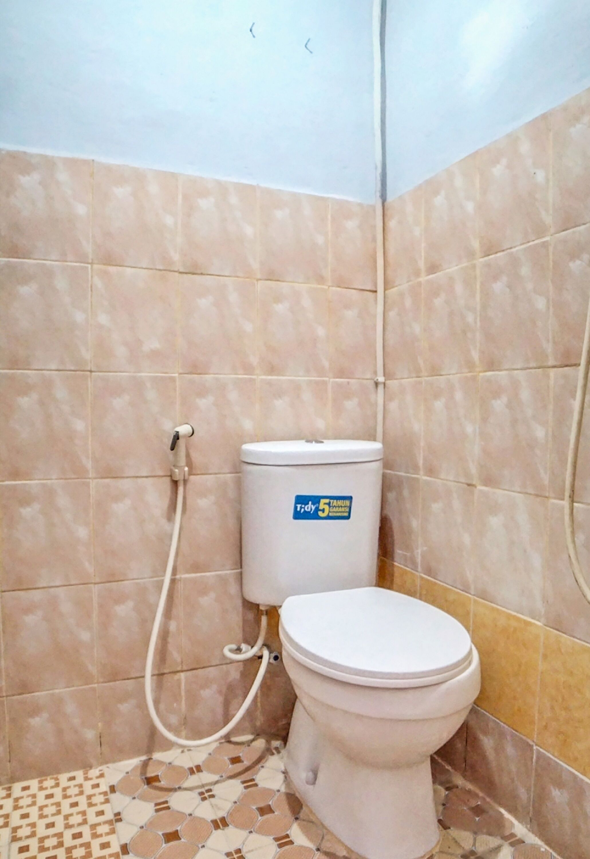 A small bathroom with a toilet, a shower, and tiled walls.
