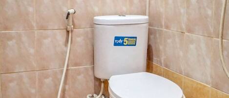 A small bathroom with a toilet, a shower, and tiled walls.