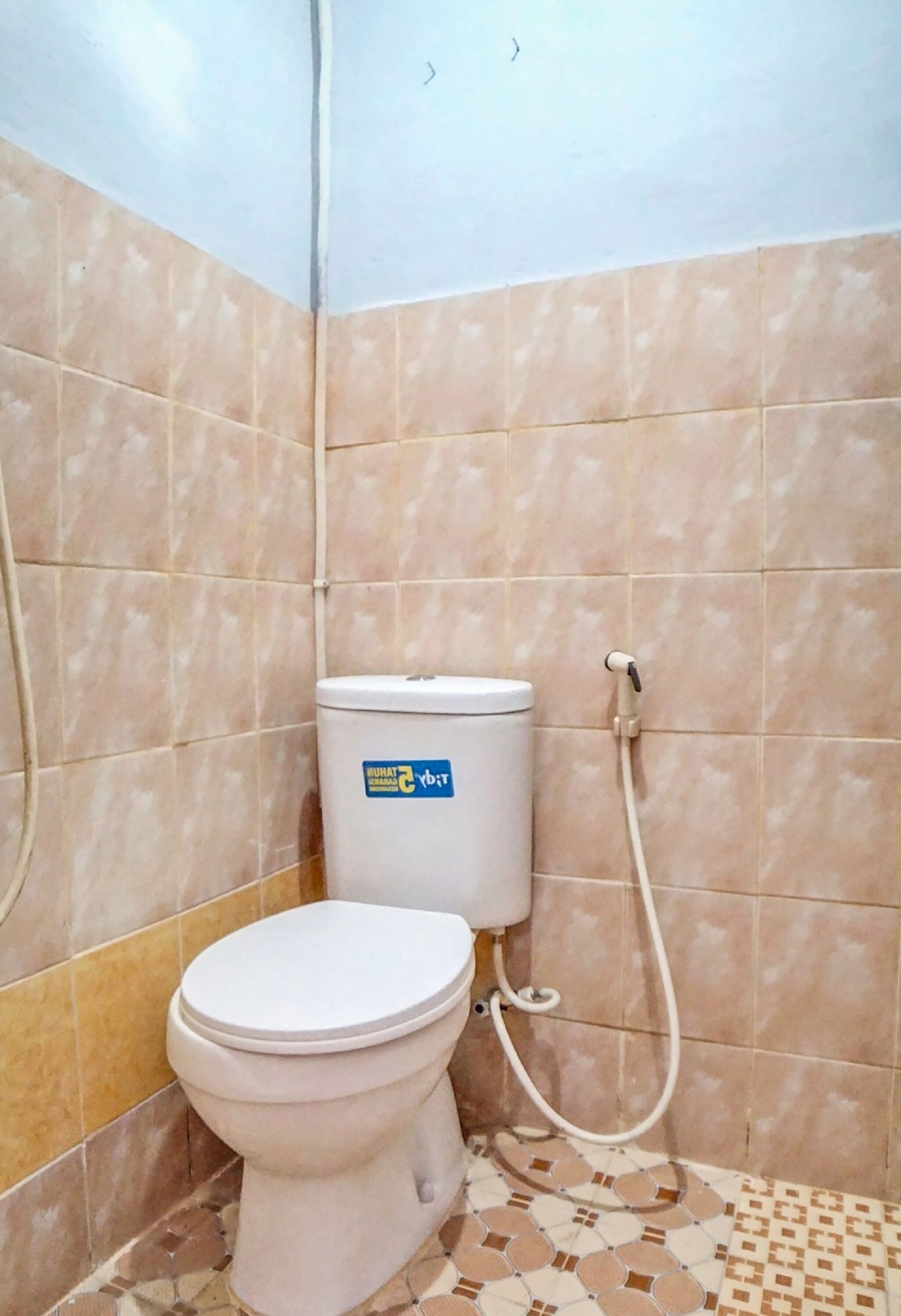 A bathroom with a toilet, a shower, and tiled walls.